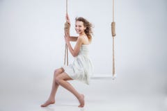 Beautiful woman sitting on swing isolated stock photo Beautiful woman sitting on swing isolated stock photo
