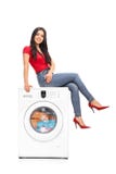 Beautiful woman sitting on a washing machine stock images Beautiful woman sitting on a washing machine stock images