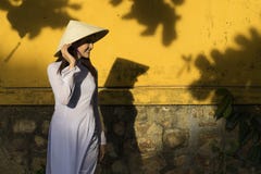 Beautiful woman with Vietnam culture traditional dress and holding hat, Ao dai is famous traditional costume, vintage style, Hoi royalty free stock images Beautiful woman with Vietnam culture traditional dress and holding hat, Ao dai is famous traditional costume, vintage style, Hoi royalty free stock images
