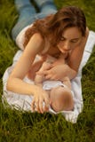 Beautiful woman with adorable baby lying on the green grass. Hap stock photos Beautiful woman with adorable baby lying on the green grass. Hap stock photos