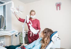 Beautiful woman dentist doing teeth whitening in the dental office stock photo Beautiful woman dentist doing teeth whitening in the dental office stock photo