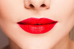 Beautiful women`s lips with bright red lipstick, stylish makeup.