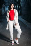 Beautiful young brunette woman in red blouse white coat evening outdoors royalty free stock image Beautiful young brunette woman in red blouse white coat evening outdoors royalty free stock image