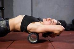 Beautiful young caucasian woman sportswoman uses a foam roller massager for relaxation, stretching muscles and back pain. Girl in stock images Beautiful young caucasian woman sportswoman uses a foam roller massager for relaxation, stretching muscles and back pain. Girl in stock images