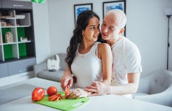Beautiful young couple grinds vegetables together in the kitchen. stock photos Beautiful young couple grinds vegetables together in the kitchen. stock photos
