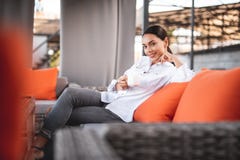Pretty young lady smiling to the camera while sitting with coffee stock images Pretty young lady smiling to the camera while sitting with coffee stock images