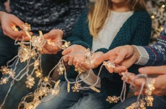 Beautiful young family enjoying their holiday time together, decorating Christmas tree, arranging the christmas lights royalty free stock photo Beautiful young family enjoying their holiday time together, decorating Christmas tree, arranging the christmas lights royalty free stock photo