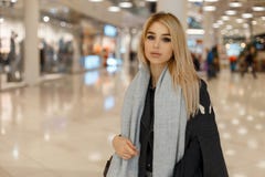 Beautiful young fashionable blond woman with gray eyes in stylish elegant autumn clothes walks through the mall stock photography Beautiful young fashionable blond woman with gray eyes in stylish elegant autumn clothes walks through the mall stock photography