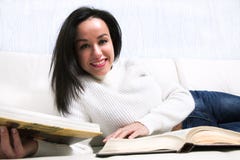 Beautiful young girl reading book lying on the couch. royalty free stock photography Beautiful young girl reading book lying on the couch. royalty free stock photography
