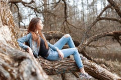 Beautiful young girl sits and dreaming on a tree branch. Stock Photography Beautiful young girl sits and dreaming on a tree branch. Stock Photography