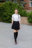 Beautiful young girl walking in the park on the background of fir branches. royalty free stock images Beautiful young girl walking in the park on the background of fir branches. royalty free stock images