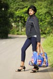 Beautiful young Indian girl with short hairs holding luggage or travel bag standing at road side, Pune stock photos Beautiful young Indian girl with short hairs holding luggage or travel bag standing at road side, Pune stock photos