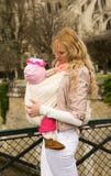 Beautiful young mother with baby daughter in sling stock photography Beautiful young mother with baby daughter in sling stock photography