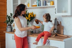 Attractive young woman and her little cute daughter are cooking on kitchen stock photo Attractive young woman and her little cute daughter are cooking on kitchen stock photo