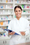 Beautiful young pharmacist holding box of medications and a clipboard stock photos Beautiful young pharmacist holding box of medications and a clipboard stock photos