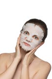 Beautiful young woman is applying a cosmetic mask on a face on a stock photo Beautiful young woman is applying a cosmetic mask on a face on a stock photo