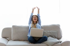 Beautiful Young Woman Celebrating A Succes While Working With Laptop At Home. Royalty Free Stock Image