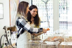 Beautiful young woman customer choosing spaghetti sold by weight in organic shop. Royalty Free Stock Image Beautiful young woman customer choosing spaghetti sold by weight in organic shop. Royalty Free Stock Image