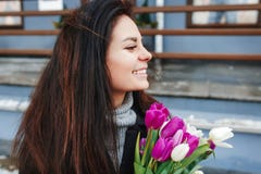 Beautiful young woman with flowers outdoor portrait, spring girl hold fresh bouquet, fashionable elegant lady at city Royalty Free Stock Images Beautiful young woman with flowers outdoor portrait, spring girl hold fresh bouquet, fashionable elegant lady at city Royalty Free Stock Images