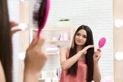 Beautiful young woman with hair brush looking into mirror royalty free stock photo Beautiful young woman with hair brush looking into mirror royalty free stock photo