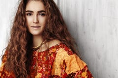 Beautiful young woman with long curly hairstyle, fashion jewelry with brunette hair. Indian style clothes, long dress Stock Photos Beautiful young woman with long curly hairstyle, fashion jewelry with brunette hair. Indian style clothes, long dress Stock Photos