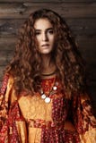 Beautiful young woman with long curly hairstyle, fashion jewelry with brunette hair. Indian style clothes, long dress Stock Images Beautiful young woman with long curly hairstyle, fashion jewelry with brunette hair. Indian style clothes, long dress Stock Images