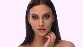 Beautiful young woman. Over white background. Very close face stock video Beautiful young woman. Over white background. Very close face stock video