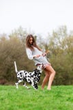Young woman plays with an Dalmatian dog outdoors Stock Image Young woman plays with an Dalmatian dog outdoors Stock Image