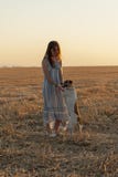 Beautiful young woman posing in a field wearing a blue and white dress, at sunset on a summer day. Red-haired. Teenager. Playing stock photos Beautiful young woman posing in a field wearing a blue and white dress, at sunset on a summer day. Red-haired. Teenager. Playing stock photos