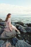 Beautiful young woman relaxing on ocean coast, romantic beauty portrait. Pretty girl sitting on rocks and dreaming stock photography Beautiful young woman relaxing on ocean coast, romantic beauty portrait. Pretty girl sitting on rocks and dreaming stock photography