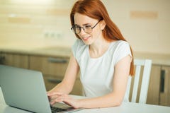 Beautiful young woman smiling and looking at laptop screen Royalty Free Stock Photos Beautiful young woman smiling and looking at laptop screen Royalty Free Stock Photos