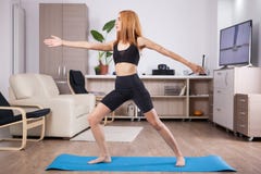 Beautiful young woman staying in Warrior II yoga pose stock photo Beautiful young woman staying in Warrior II yoga pose stock photo