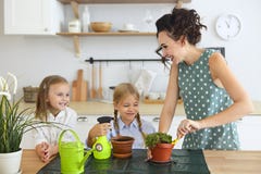 Beautiful young women with two little cute daughters planting flower in pot royalty free stock image Beautiful young women with two little cute daughters planting flower in pot royalty free stock image