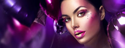 Beauty fashion model girl creative art makeup with gems. Woman face over purple, pink and violet air balloons