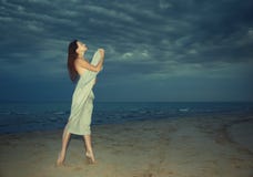 Beauty at the night beach. Nifty lady covered by towel standing at the night beach stock image Beauty at the night beach. Nifty lady covered by towel standing at the night beach stock image