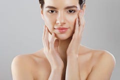 Beauty and Spa Concept. Beautiful Young Woman with Clean Fresh Skin touch own face and Smiling.Facial treatment. Girl Female With royalty free stock photo Beauty and Spa Concept. Beautiful Young Woman with Clean Fresh Skin touch own face and Smiling.Facial treatment. Girl Female With royalty free stock photo