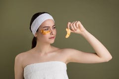 Beauty teen girl with bare shoulders looking at gold patch in hand royalty free stock photo Beauty teen girl with bare shoulders looking at gold patch in hand royalty free stock photo