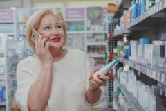 Beaux achats sup?rieurs de femme ? la pharmacie photographie stock Beaux achats sup?rieurs de femme ? la pharmacie photographie stock