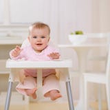 Bebé en el highchair que espera para ser introducido imágenes de archivo libres de regalías Bebé en el highchair que espera para ser introducido imágenes de archivo libres de regalías