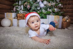 Bebé en el traje del duende que juega con el tren de madera viejo y los osos suaves del juguete debajo del árbol de navidad, vint foto de archivo libre de regalías Bebé en el traje del duende que juega con el tren de madera viejo y los osos suaves del juguete debajo del árbol de navidad, vint foto de archivo libre de regalías