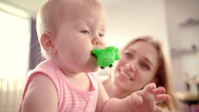 Bebé lindo con el juguete Bebé infantil que mira alrededor Familia cariñosa feliz metrajes Bebé lindo con el juguete Bebé infantil que mira alrededor Familia cariñosa feliz metrajes