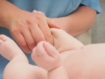 Bebê caucasiano pequeno da massagem do doutor imagens de stock Bebê caucasiano pequeno da massagem do doutor imagens de stock