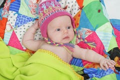 Bebê com chapéu e o quilt coloridos imagens de stock Bebê com chapéu e o quilt coloridos imagens de stock