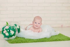 Bebê de olhos azuis bonito que encontra-se na barriga Imagens de Stock Bebê de olhos azuis bonito que encontra-se na barriga Imagens de Stock