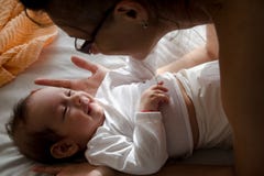 Bebê e mamã que abraçam e que sorriem em se fotos de stock Bebê e mamã que abraçam e que sorriem em se fotos de stock