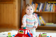 Bebê pequeno bonito bonito adorável que joga com os brinquedos de madeira educacionais em casa ou o berçário Criança com colorido fotografia de stock Bebê pequeno bonito bonito adorável que joga com os brinquedos de madeira educacionais em casa ou o berçário Criança com colorido fotografia de stock