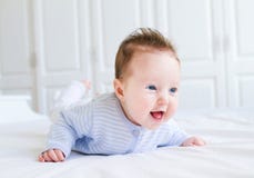 Bebê pequeno de riso bonito que aprecia seu tempo da barriga imagens de stock Bebê pequeno de riso bonito que aprecia seu tempo da barriga imagens de stock