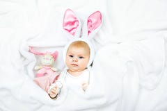Bebê recém-nascido bonito adorável no traje e nas orelhas do coelhinho da Páscoa Criança bonita que joga com o brinquedo do coelh imagem de stock Bebê recém-nascido bonito adorável no traje e nas orelhas do coelhinho da Páscoa Criança bonita que joga com o brinquedo do coelh imagem de stock