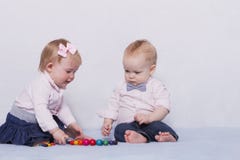 Bebês infantis bonitos que jogam com grânulos coloridos fotos de stock Bebês infantis bonitos que jogam com grânulos coloridos fotos de stock