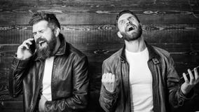 Bedrijfs vraag Mensen brutale gebaarde hipster in modieuze het gebruiks mobiele telefoon van leerjasjes Online zaken modern stock foto Bedrijfs vraag Mensen brutale gebaarde hipster in modieuze het gebruiks mobiele telefoon van leerjasjes Online zaken modern stock foto
